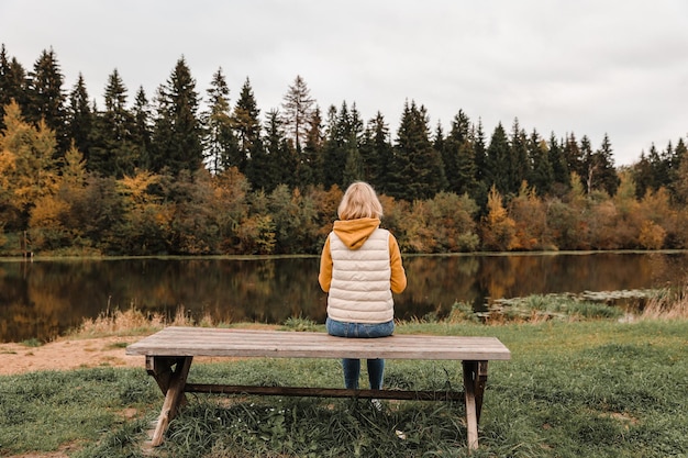 La mujer está en el parque de otoño Atmósfera otoñal vista panorámica del río