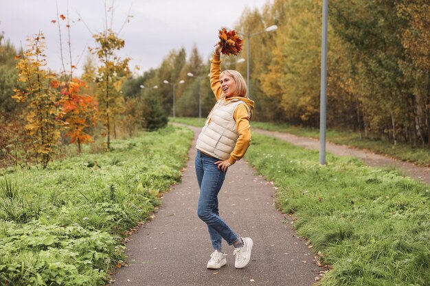 La mujer está en el parque de otoño Paseo por el bosque Atmósfera otoñal