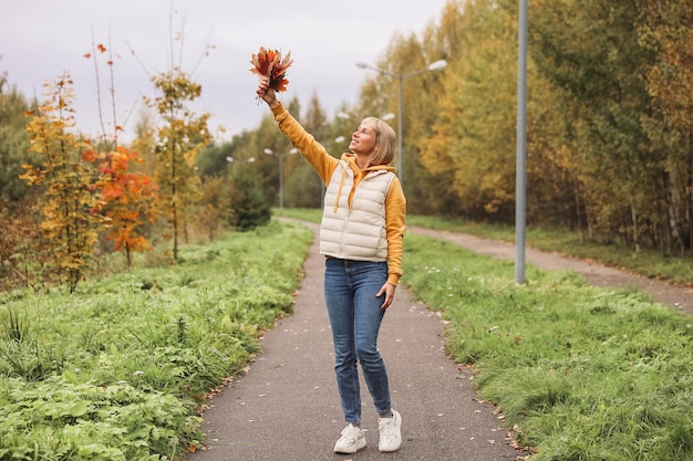 La mujer está en el parque de otoño Paseo por el bosque Atmósfera otoñal