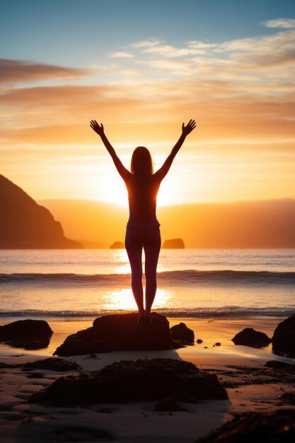 Una mujer está de pie en la playa al amanecer