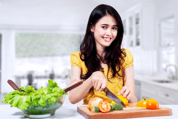 La mujer está preparando ensalada.