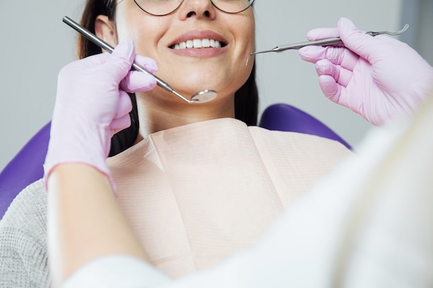 Una mujer se está preparando para un examen dental. Mujer que tiene los dientes examinados en los dentistas.