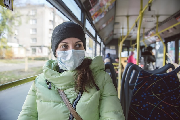 Una mujer está protegida contra virus en el transporte público.