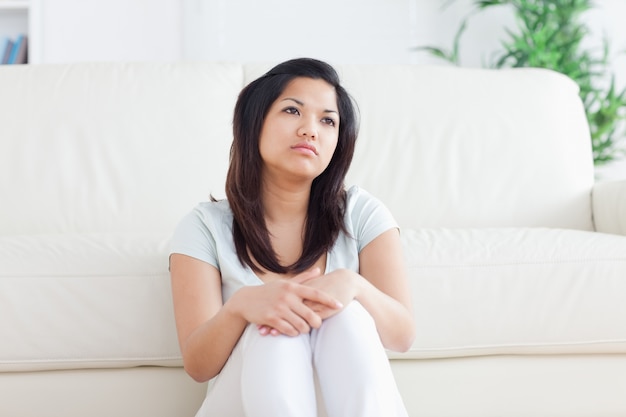 La mujer está sentada frente a un sofá