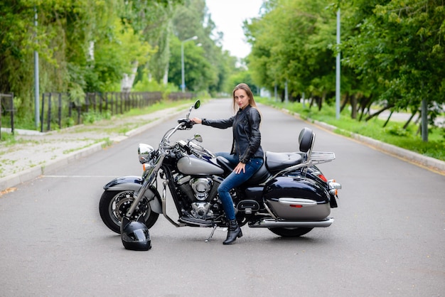 La mujer está sentada en una motocicleta y sonriendo.