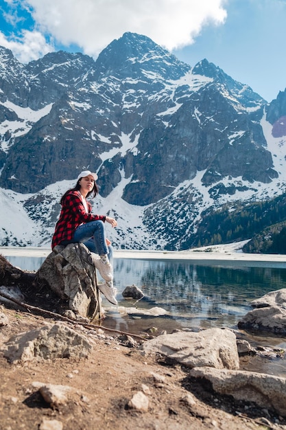 Una mujer está sentada en la orilla de un lago Morskie Oko Tatras montañas