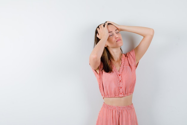 La mujer está soñando sosteniendo su cabeza con fondo blanco.