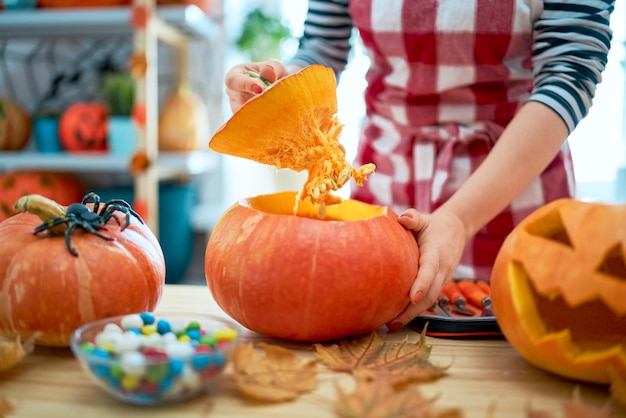 La mujer está tallando calabaza