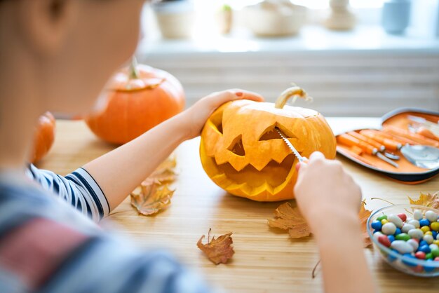 La mujer está tallando calabaza