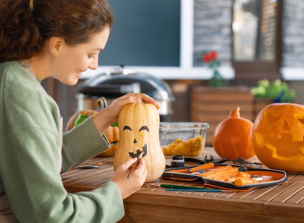 La mujer está tallando calabazas