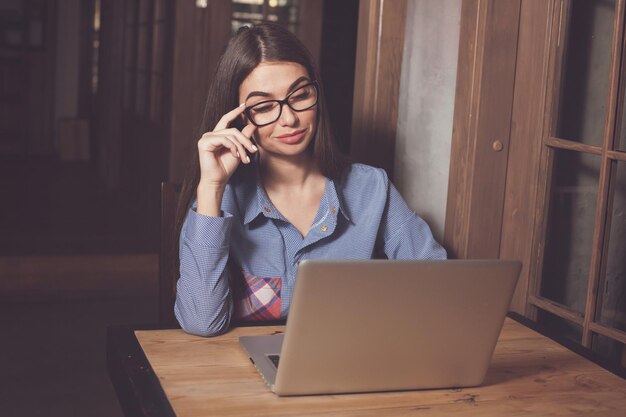 La mujer está trabajando en algo en la mesa.