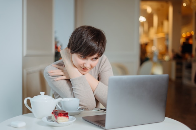 Mujer está trabajando en la PC en el cibercafé