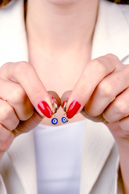 una mujer está usando esmalte de uñas rojo y está sosteniendo un alfiler con el número 8 en él