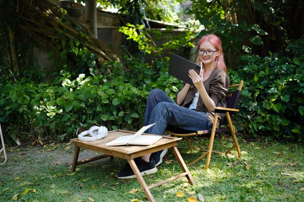 La mujer está usando una tableta digital en el jardín