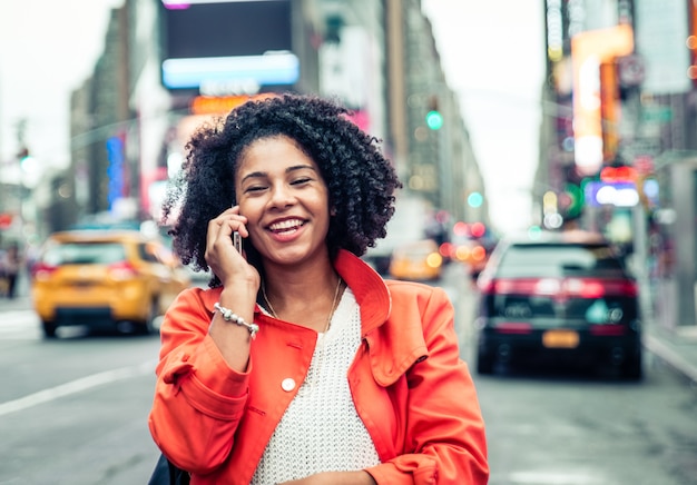 Mujer estadounidense haciendo una llamada telefónica en Time Square, Nueva York. concepto de estilo de vida urbano