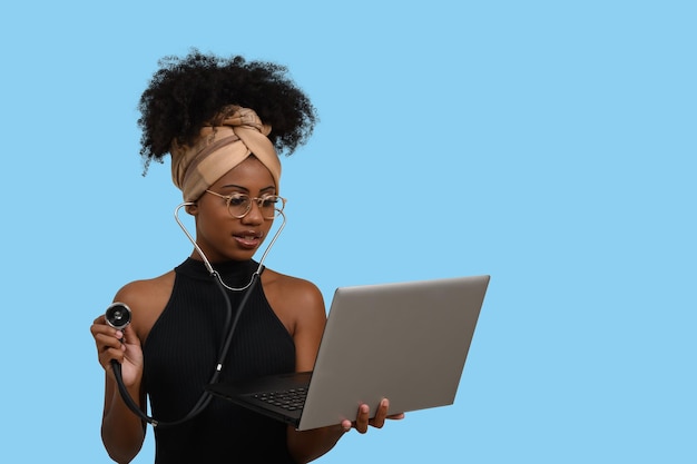 Una mujer con un estetoscopio y una computadora portátil.