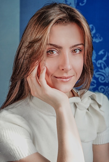 Mujer en estilo casual y maquillaje natural sobre fondo azul.