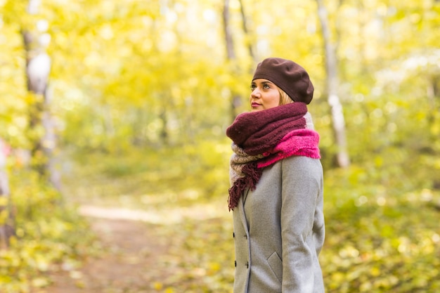 Mujer con estilo joven caminando en el parque otoño