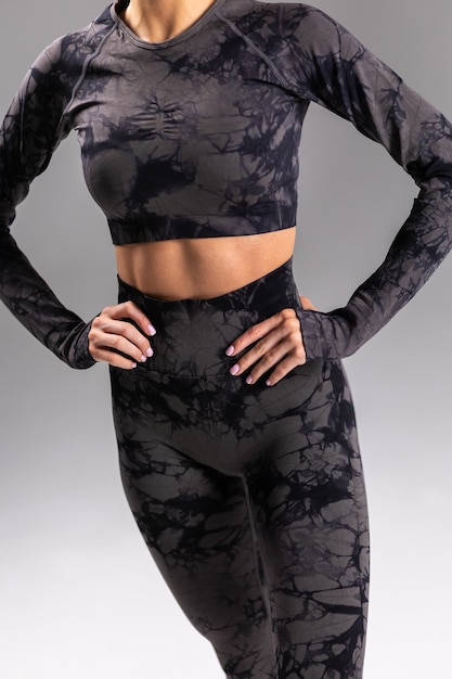 Mujer con estilo patrón de mármol negro ropa activa camiseta y leggings ropa de acondicionamiento físico moda tendencia concepto de ropa atlética