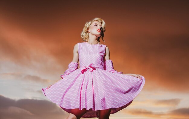 Mujer de estilo pinup en vestido de verano en el cielo dramático modelo joven de moda en vestido de estilo moda wom