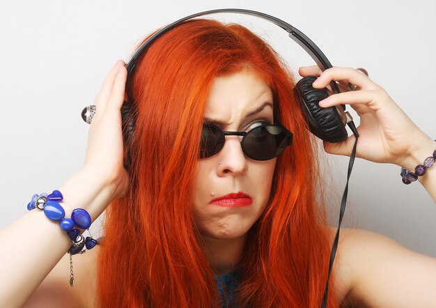 Mujer de estilo rock con auriculares escuchando música