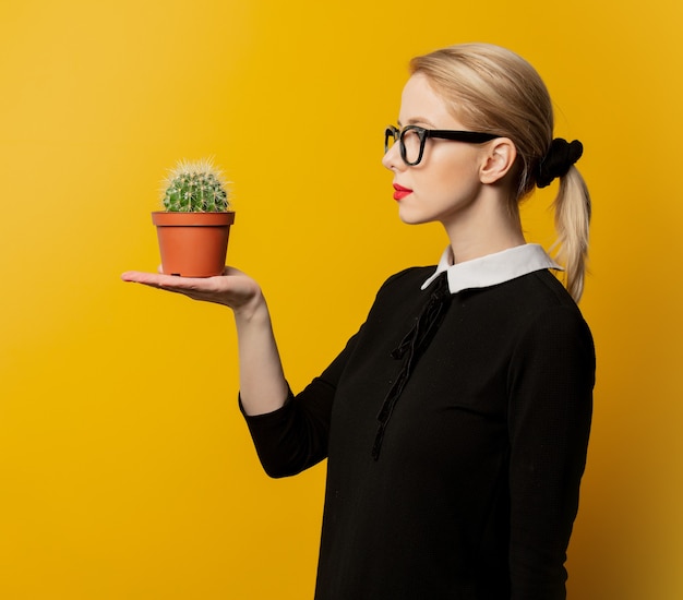 Mujer de estilo en ropa formal negra con cactus