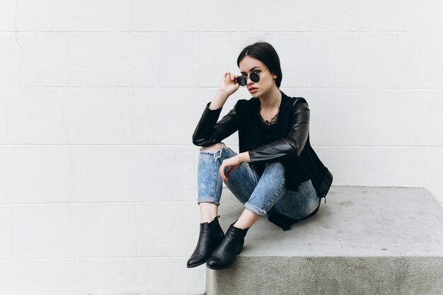 Mujer con estilo tocando gafas de sol