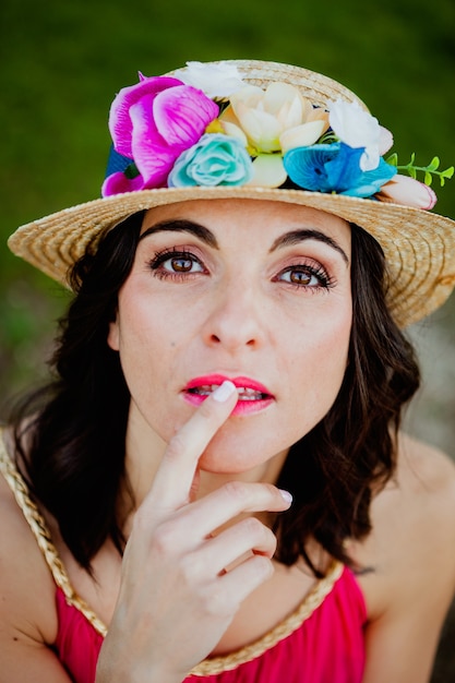 Mujer con estilo con un vestido rojo y sombrero de paja con flores