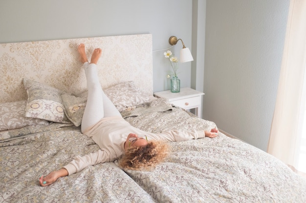 Mujer de estilo de vida casero relajante por la mañana en la cama en el dormitorio de la casa