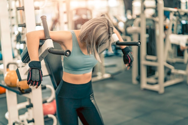 Foto mujer estirando los brazos y preparándose antes de hacer ejercicio en el gimnasio