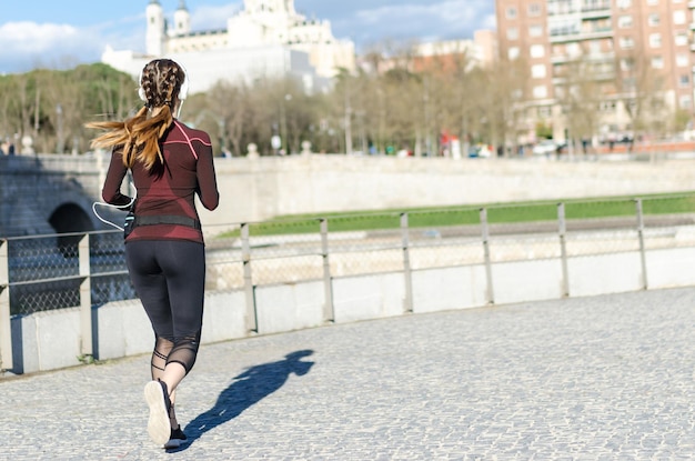 Foto mujer estirándose descansando después de correr y correr en un parque con ropa deportiva