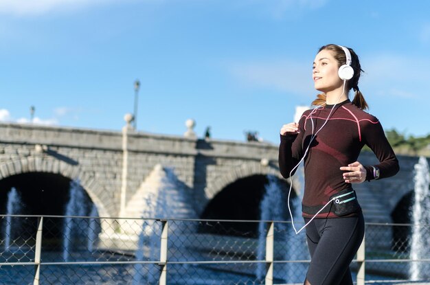 mujer estirándose descansando después de correr y correr en un parque con ropa deportiva