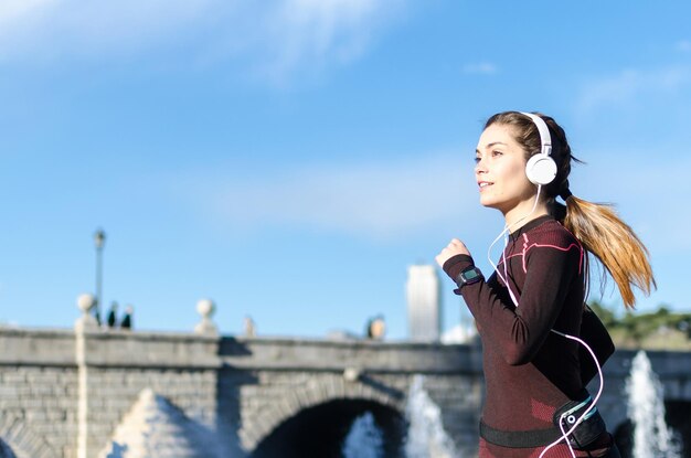 Foto mujer estirándose descansando después de correr y correr en un parque con ropa deportiva