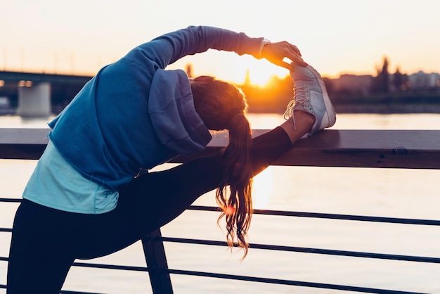 Mujer estirándose después de entrenar al aire libre