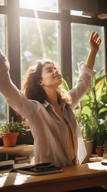 Foto mujer estirándose en el escritorio con la luz del sol entrando