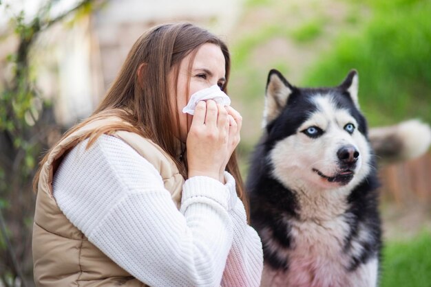 Foto una mujer estornuda y sopla la nariz en una servilleta sufre de alergia a la piel de mascotas