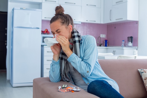 Mujer estornudando se resfrió. Tratamiento de gripe en casa