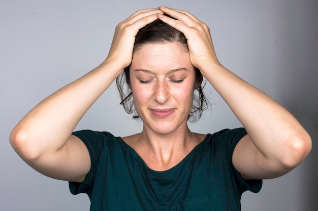 Mujer estresada manteniendo las manos en el retrato de la cabeza