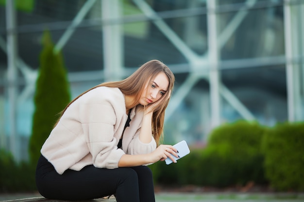 Mujer estresada del trabajo mientras está sentado al aire libre