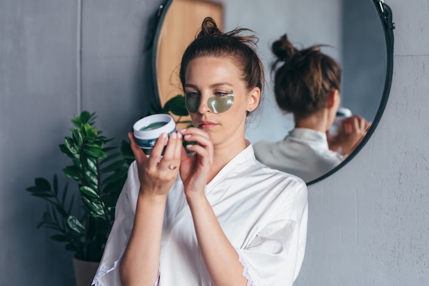 La mujer estudia las instrucciones para el uso de parches para los ojos.