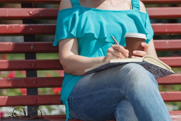 Foto mujer estudiando y escribiendo en un parque