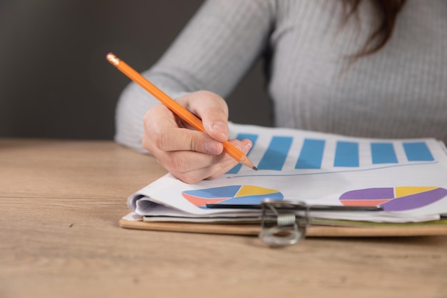 Foto mujer estudiando papeles con gráficos