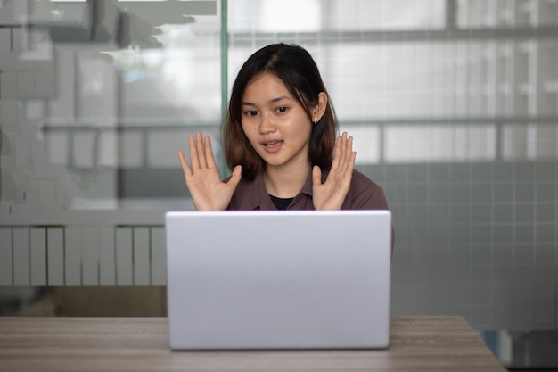 Mujer estudiante asiática que trabaja en una computadora portátil durante el día