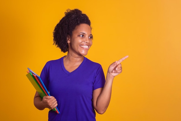 Mujer estudiante madura sonriendo mirando a la cámara con espacio para texto sobre fondo amarillo