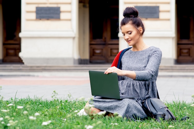 Mujer estudiante usando laptop en la universidad