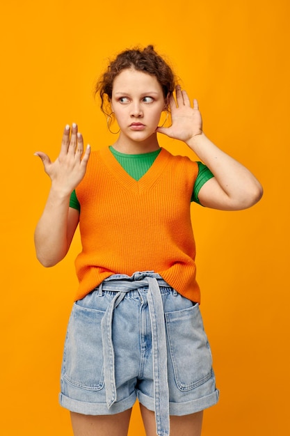 Mujer en estudio de estilo juvenil de moda de suéter naranja