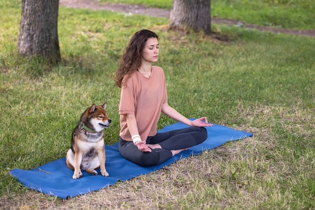 Una mujer europea deportiva hace yoga y meditación en un parque o un lugar público una mujer hace deporte