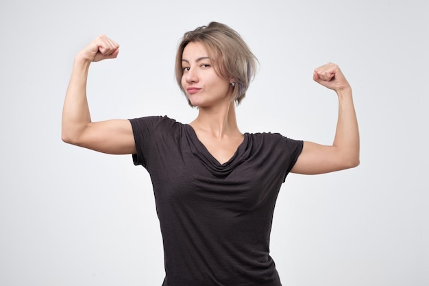 Mujer europea joven feliz que muestra su mano fuerte