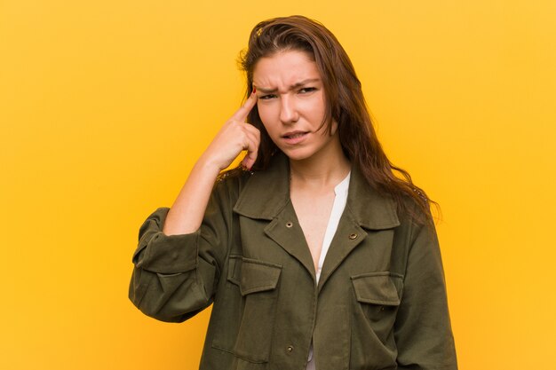 Mujer europea joven que muestra un gesto de decepción con el índice.