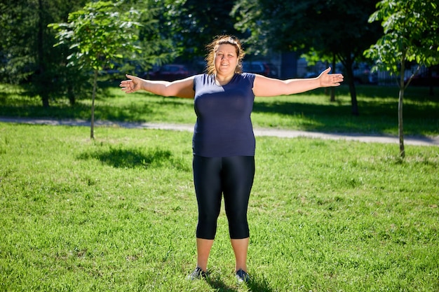 Mujer europea obesa haciendo ejercicios matutinos en la naturaleza